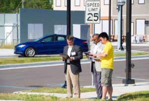 Three men checking documents at m city test facility