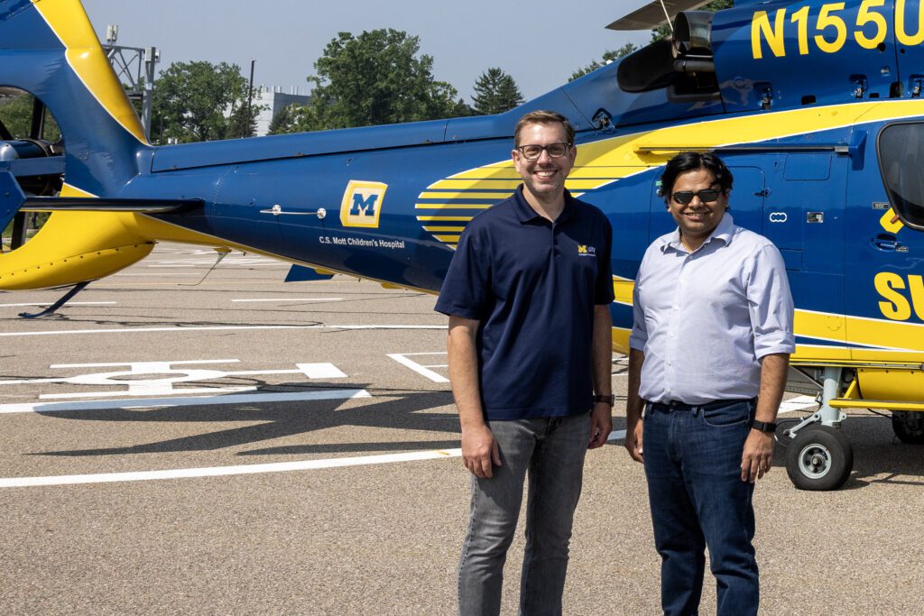 Mcity Managing Director Greg McGurie on left with M-air Director Venkat Viswanathan standing in front of the Survival Flight helicopter at the Mcity Test Facility