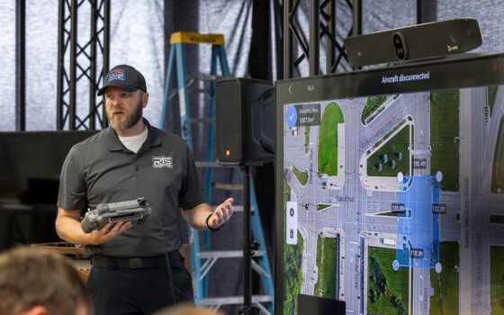 Drone training instructor stands in front of a television