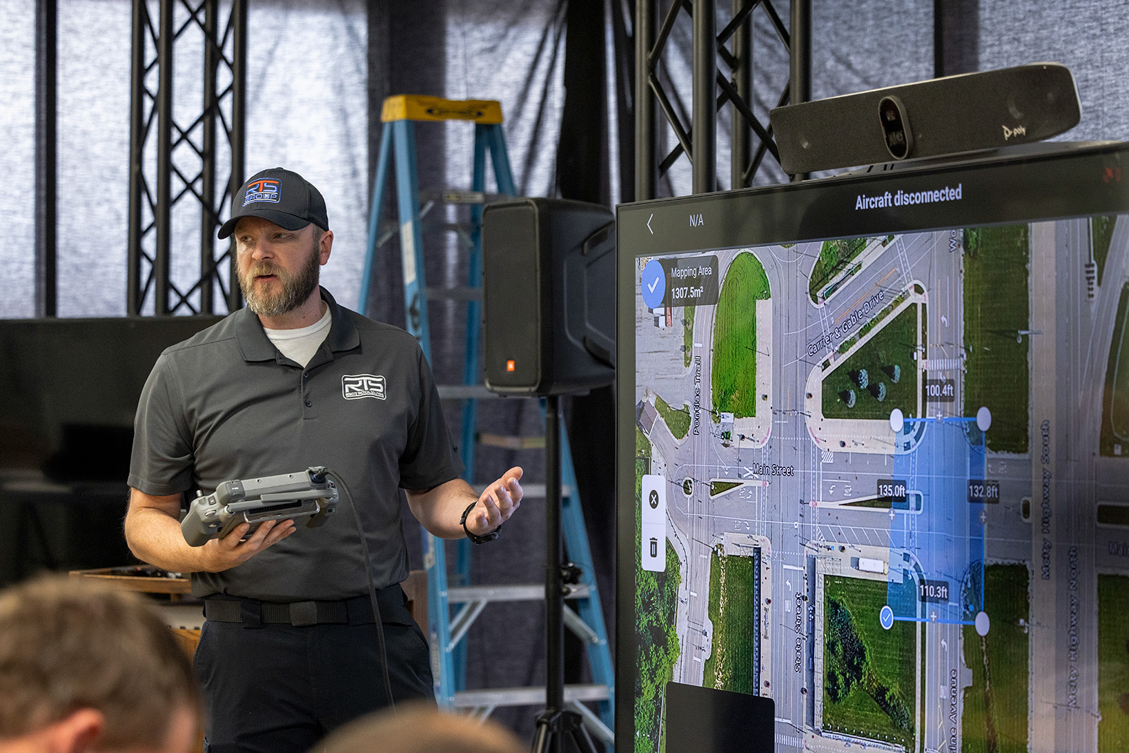 Drone training instructor stands in front of a television